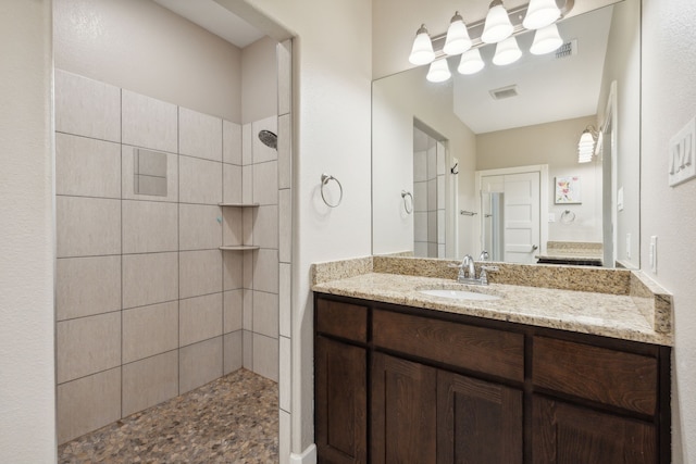 bathroom with vanity and a tile shower