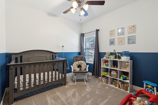 bedroom featuring ceiling fan, a nursery area, and carpet