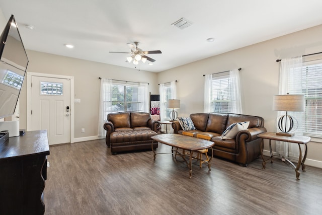 living room with a wealth of natural light, ceiling fan, and dark hardwood / wood-style floors