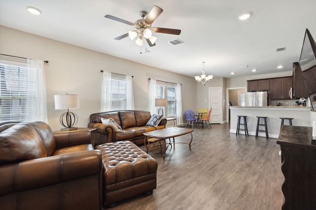 living room featuring hardwood / wood-style floors and ceiling fan with notable chandelier