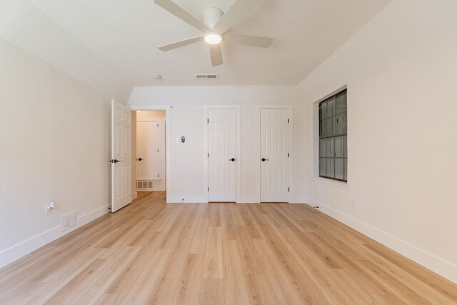 unfurnished bedroom with two closets, ceiling fan, and light hardwood / wood-style floors