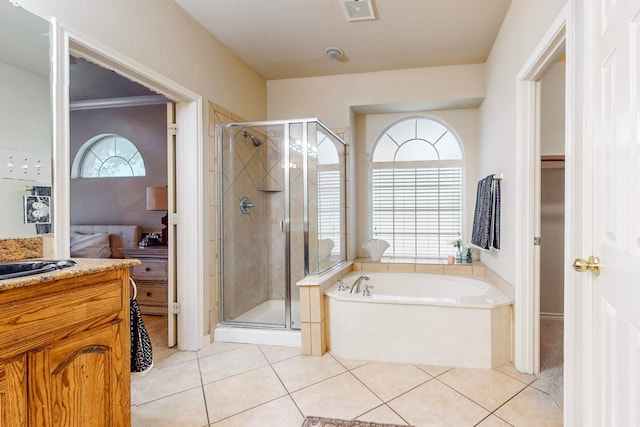 bathroom featuring tile patterned flooring, shower with separate bathtub, and vanity