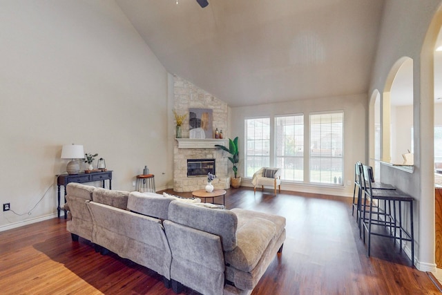 living room with high vaulted ceiling, ceiling fan, a fireplace, and dark hardwood / wood-style flooring