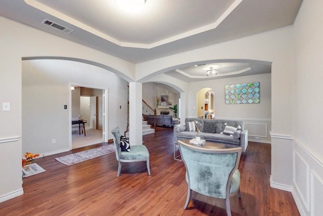 dining room with dark hardwood / wood-style floors and a raised ceiling