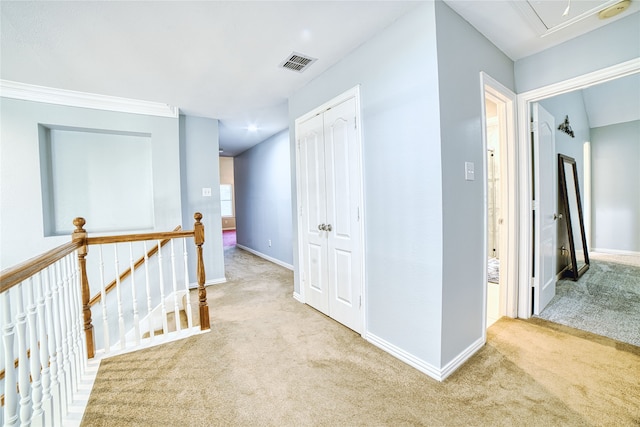 corridor with light carpet and crown molding