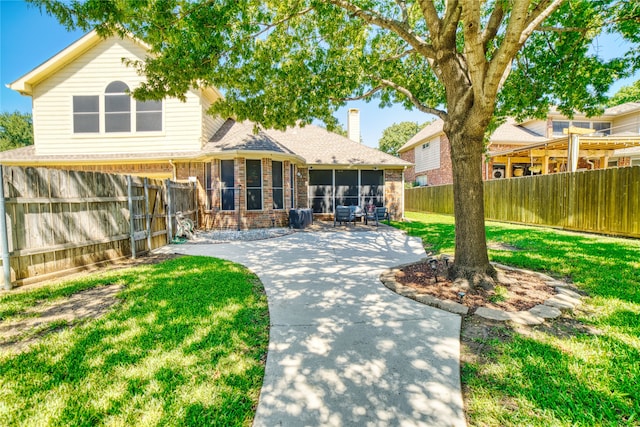 rear view of property featuring a sunroom and a yard