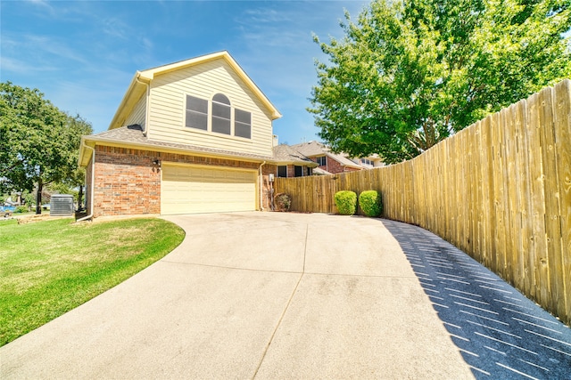 view of front of home with central AC unit, a garage, and a front lawn