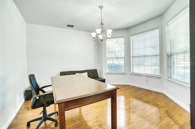 home office featuring light hardwood / wood-style flooring and a chandelier