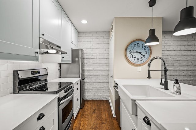 kitchen featuring brick wall, stainless steel electric stove, decorative light fixtures, dark hardwood / wood-style floors, and white cabinetry