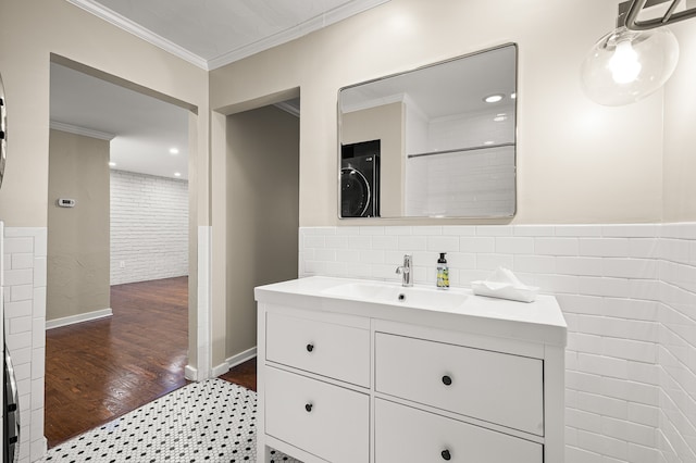 bathroom featuring vanity, wood-type flooring, tile walls, and ornamental molding