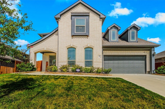 view of front of home featuring brick siding, a garage, driveway, and a front lawn