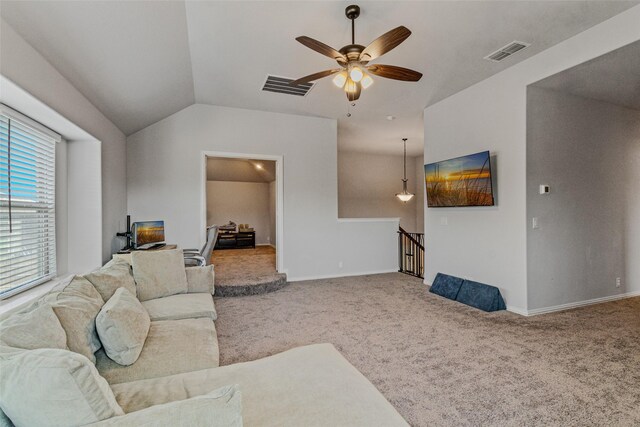 living area with visible vents, ceiling fan, carpet, and vaulted ceiling