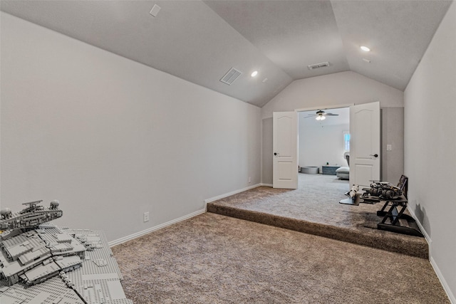 interior space with vaulted ceiling, carpet flooring, baseboards, and visible vents