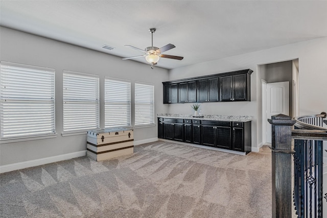 kitchen featuring ceiling fan and light colored carpet