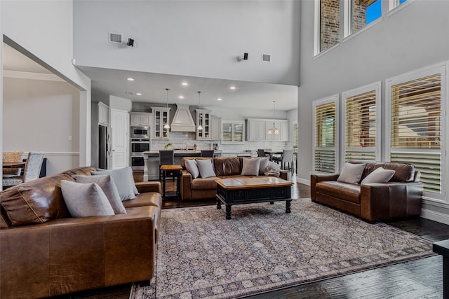 living room featuring dark wood-type flooring and a towering ceiling