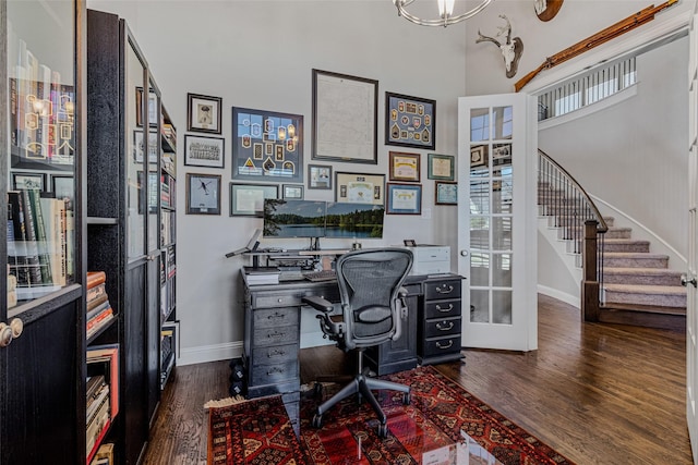 office with a high ceiling, dark hardwood / wood-style floors, and french doors