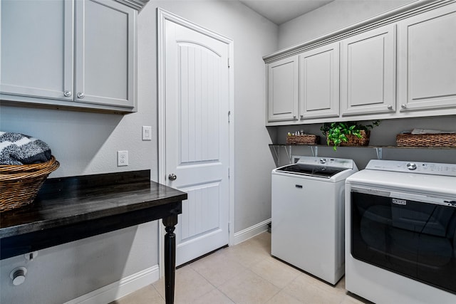 clothes washing area featuring cabinets, light tile patterned flooring, and independent washer and dryer