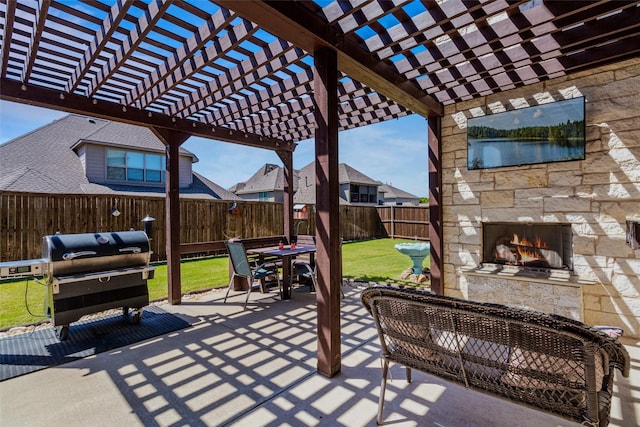 view of patio / terrace with area for grilling, an outdoor stone fireplace, and a pergola