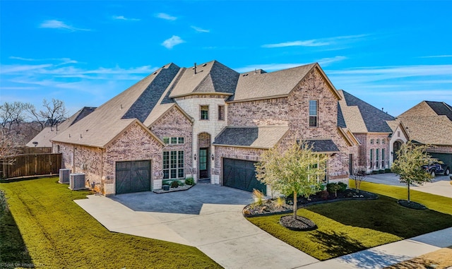 french country inspired facade with a garage, central AC, and a front yard