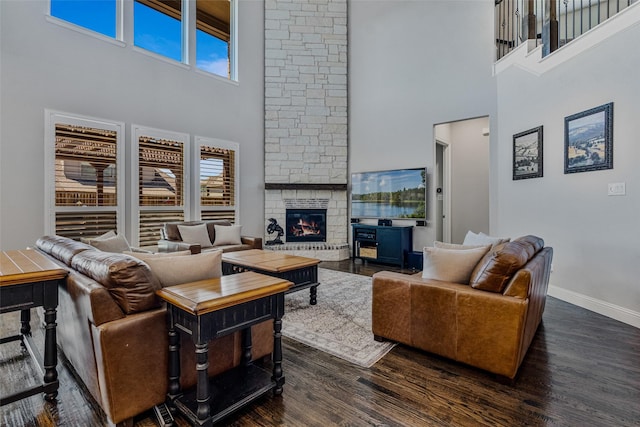 living room with dark hardwood / wood-style floors, a wealth of natural light, and a high ceiling