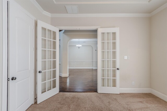 empty room with carpet, ornamental molding, and french doors