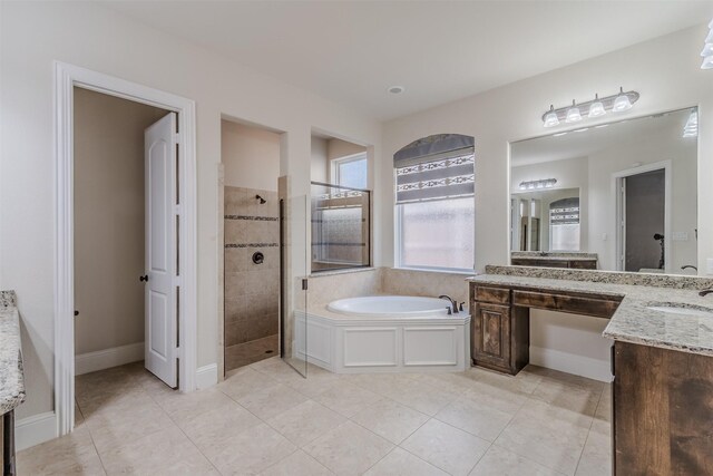 bathroom with tile patterned flooring, shower with separate bathtub, and vanity