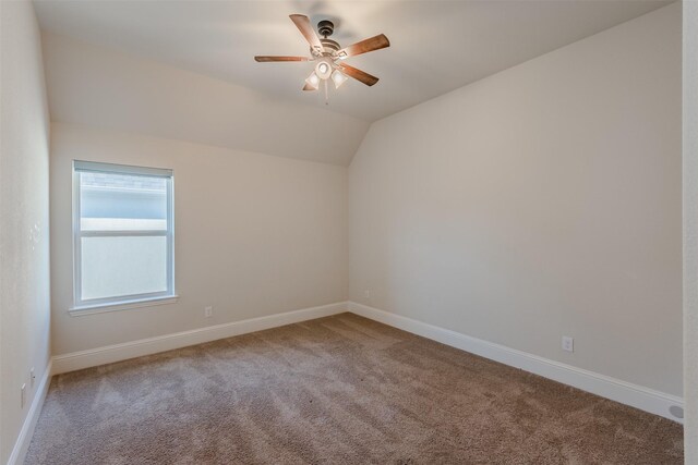 carpeted spare room featuring lofted ceiling and ceiling fan