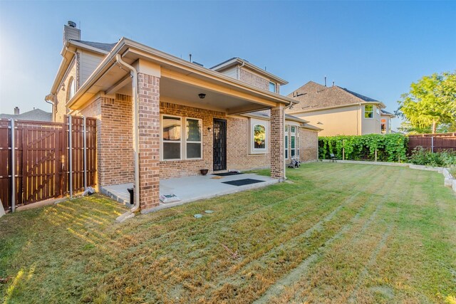 rear view of property featuring a patio area and a yard