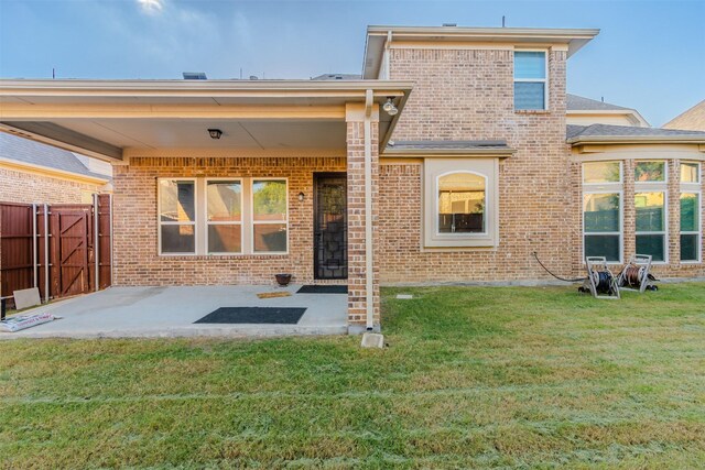 rear view of property with a yard and a patio