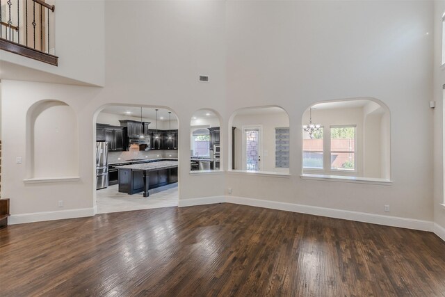 unfurnished living room with dark hardwood / wood-style floors and a chandelier