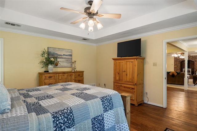 bedroom with a raised ceiling, crown molding, ceiling fan with notable chandelier, and dark hardwood / wood-style flooring