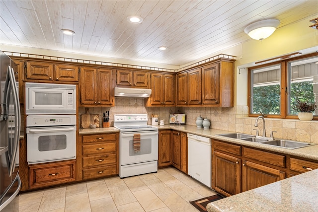 kitchen with white appliances, tasteful backsplash, light stone counters, sink, and wooden ceiling