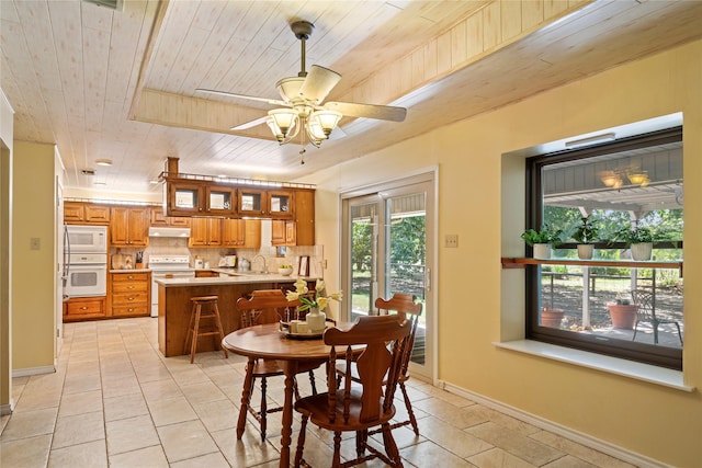 dining area with light tile patterned floors, ceiling fan, and wood ceiling