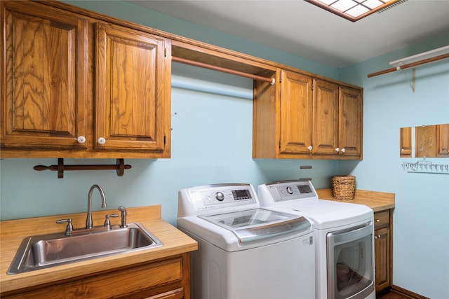 laundry room featuring sink, cabinets, and washing machine and clothes dryer