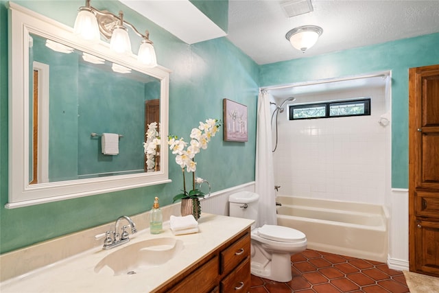 full bathroom featuring vanity, toilet, shower / bathtub combination with curtain, tile patterned floors, and a textured ceiling