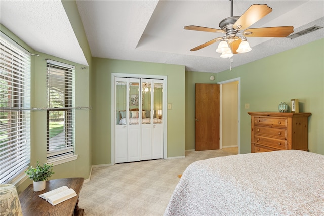 bedroom with a textured ceiling, ceiling fan, and a closet