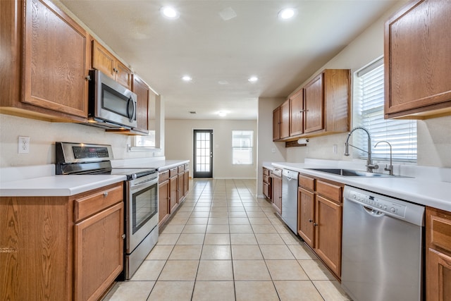 kitchen with sink, light tile patterned floors, and appliances with stainless steel finishes