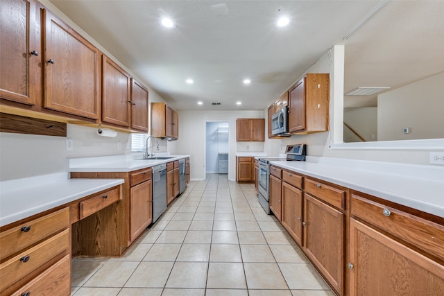 kitchen with light tile patterned floors, stainless steel appliances, and sink