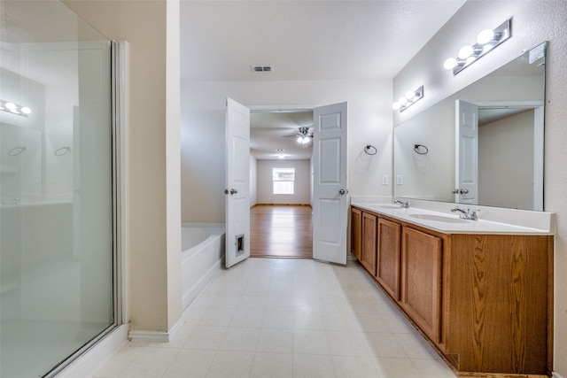 bathroom featuring plus walk in shower, ceiling fan, and vanity