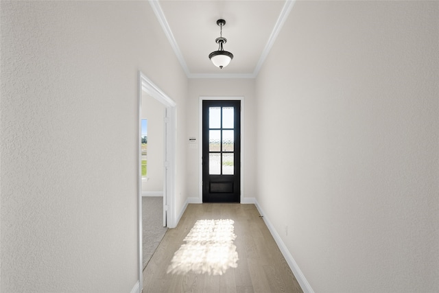 doorway featuring crown molding and light hardwood / wood-style floors