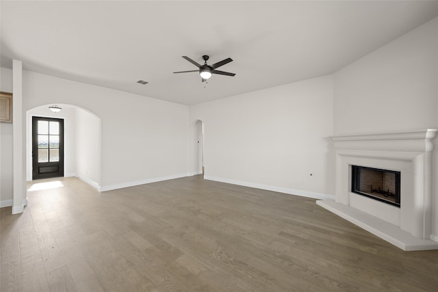 unfurnished living room with ceiling fan and wood-type flooring