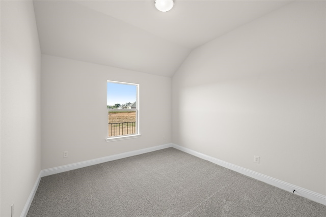 spare room with carpet floors and lofted ceiling