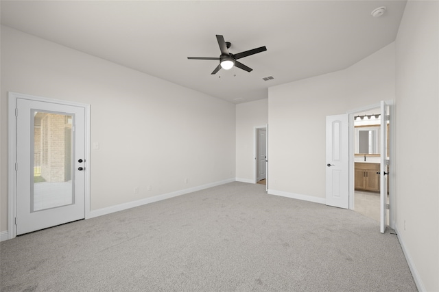 unfurnished bedroom featuring ceiling fan, light colored carpet, access to outside, and ensuite bath