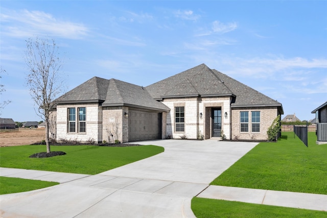 french provincial home featuring a front yard and a garage