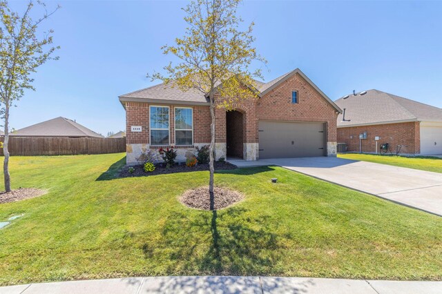 view of front of home with cooling unit, a garage, and a front lawn