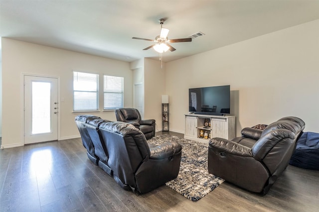 living area with visible vents, baseboards, dark wood-type flooring, and ceiling fan