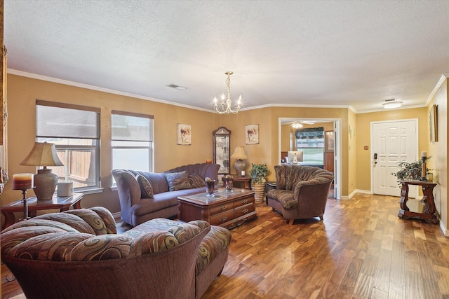 living room with a textured ceiling, a chandelier, crown molding, and hardwood / wood-style floors