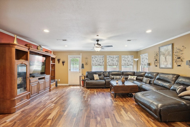 living room featuring a textured ceiling, ceiling fan, ornamental molding, and hardwood / wood-style floors