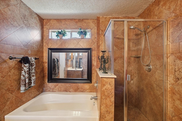 bathroom featuring a textured ceiling, plus walk in shower, and vanity