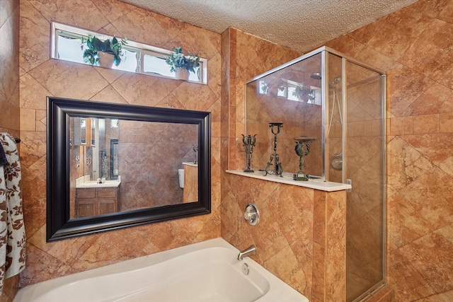 bathroom with a textured ceiling, separate shower and tub, and vanity